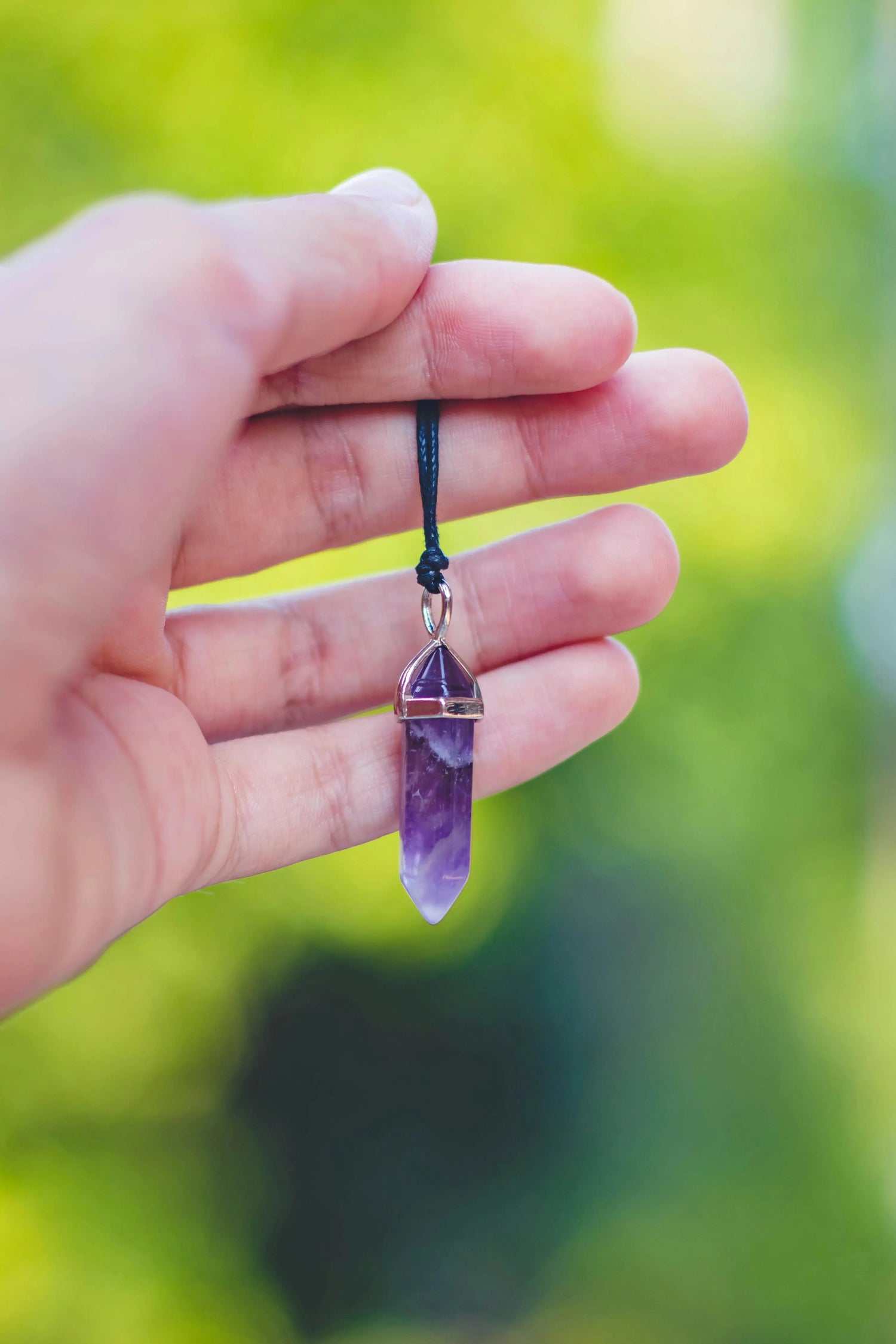 pendentif pierre naturelle dans main 