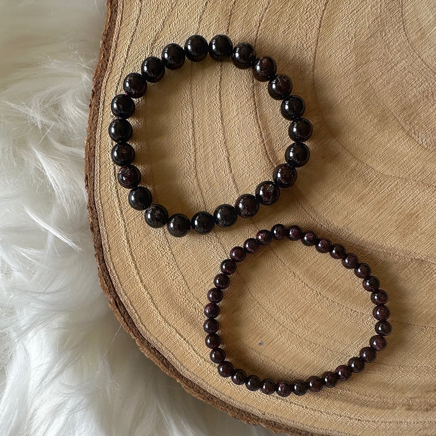 bracelet grenat rouge sur bois vu du haut 