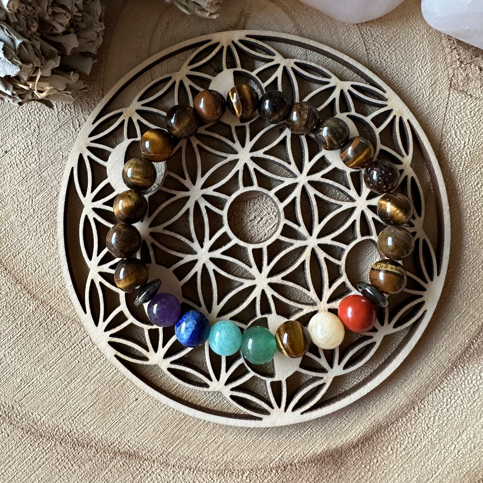 Plaque en bois fleur de vie et bracelet par dessus 